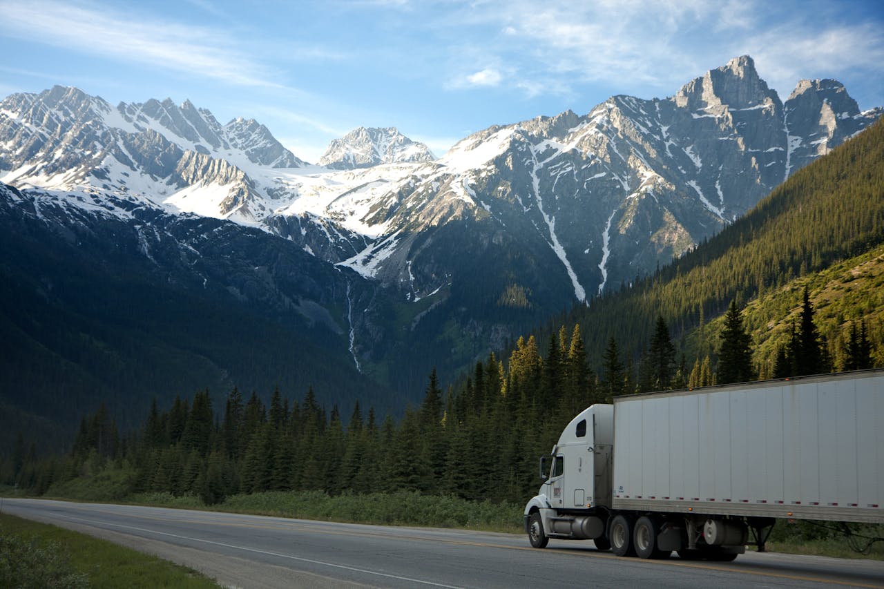 Crafting Captivating Headlines: Your awesome post title goes here A semi-truck travels along a highway with snow-capped mountains in the background.